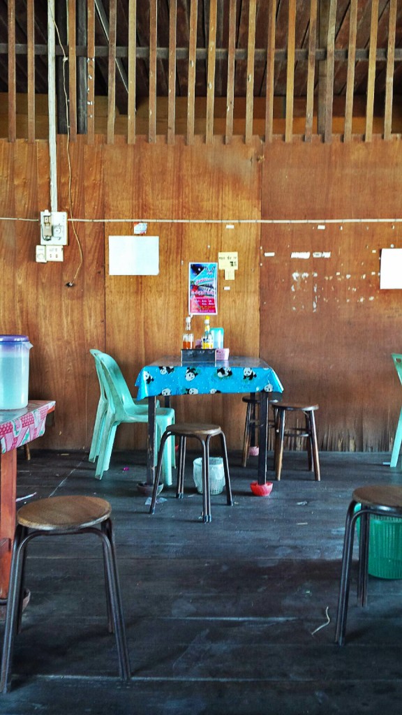 Table against the wall that's made from cheap wood.