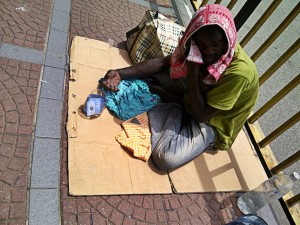 Under the scorching sun, surrounded by Malaysian monuments of development, this man begs for coins.